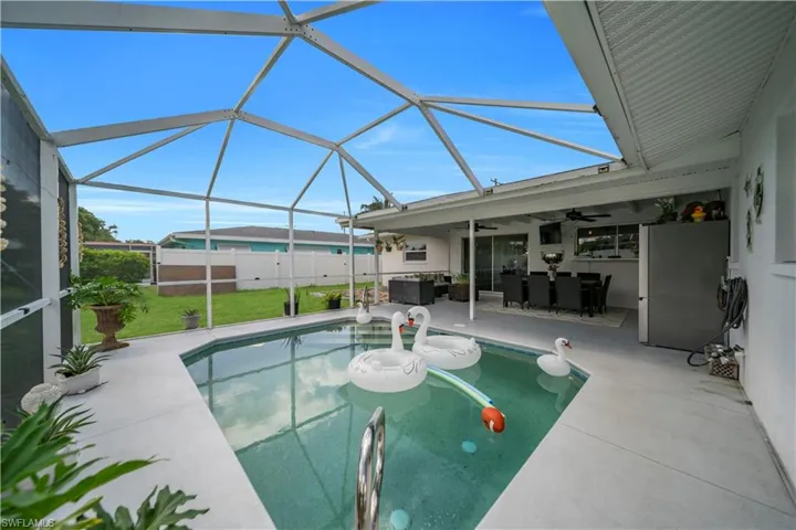 Swimming pool with ceiling fan, a patio, a lanai, and outdoor lounge area