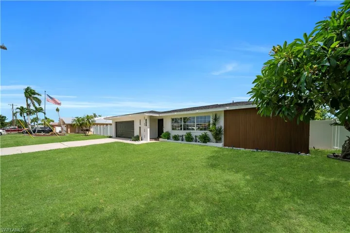 View of front of property with driveway, a garage, and a front yard