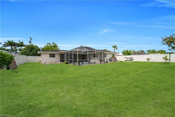 Fenced backyard featuring a lanai