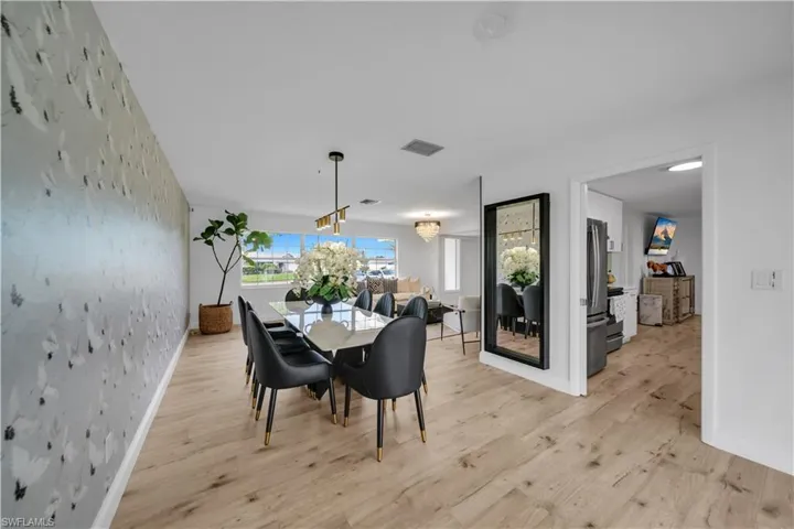 Dining space with light wood-style floors and wallpapered walls