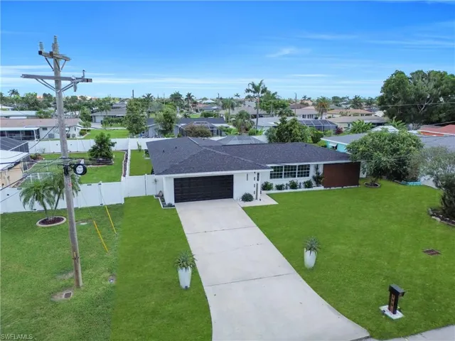 Ranch-style house featuring concrete driveway, a garage, a residential view, roof with shingles, and stucco siding