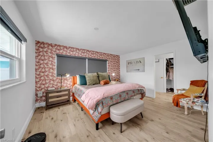 Bedroom with wood finished floors and a spacious closet