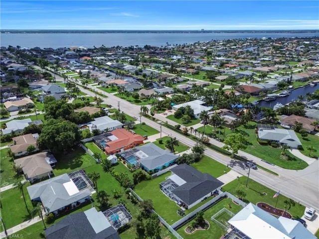 Aerial view of property's location featuring a nearby body of water and nearby suburban area