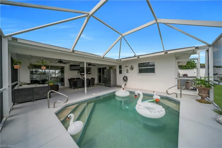 Outdoor pool with ceiling fan, a patio area, outdoor lounge area, and a lanai