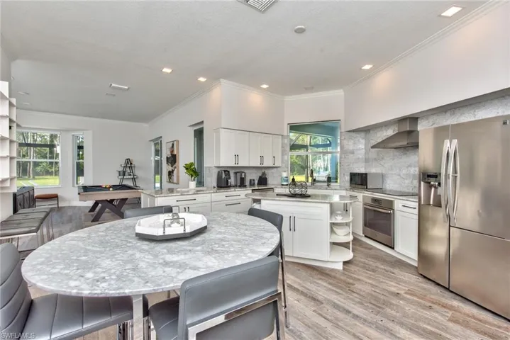 Kitchen with a wealth of natural light, backsplash, stainless steel appliances, and a kitchen island