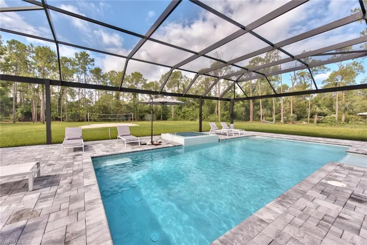 View of pool featuring a lanai, a patio area, and a yard