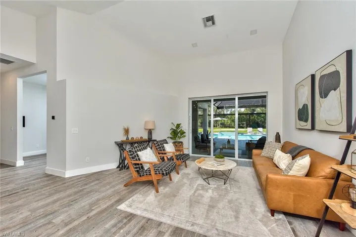Living room with hardwood / wood-style floors and high vaulted ceiling