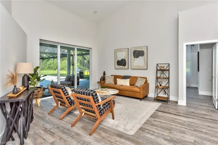 Living room with hardwood / wood-style flooring and high vaulted ceiling