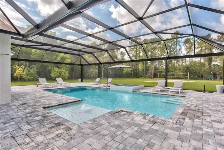 View of swimming pool featuring a patio, an in ground hot tub, a lanai, and a yard
