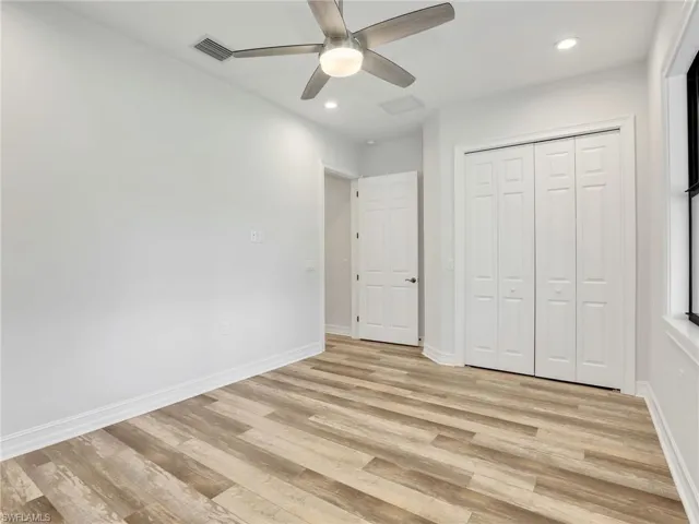 Unfurnished bedroom with light wood-type flooring, recessed lighting, ceiling fan, and a closet