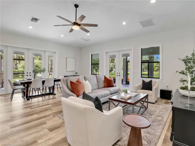 Living area featuring french doors, recessed lighting, light wood finished floors, plenty of natural light, and ceiling fan