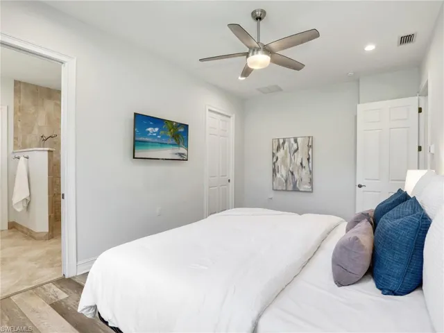Bedroom featuring wood finished floors, ensuite bath, ceiling fan, and recessed lighting