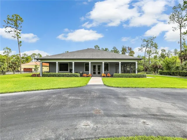 View of front of home with a front lawn, roof with shingles, and french doors