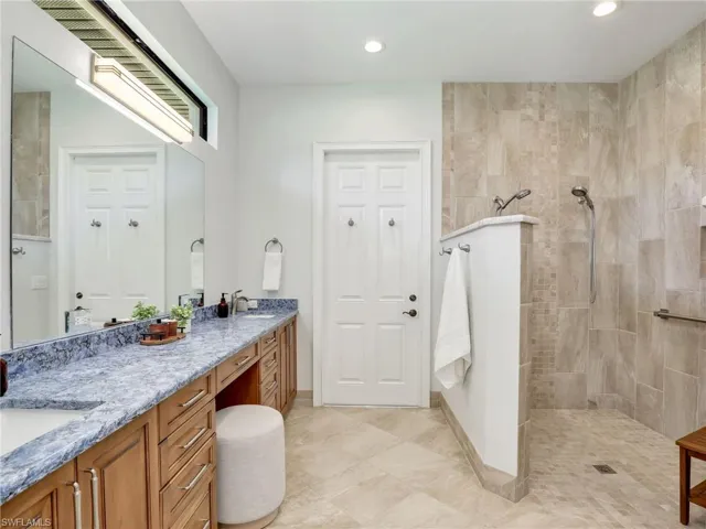 Bathroom with double vanity, walk in shower, and recessed lighting