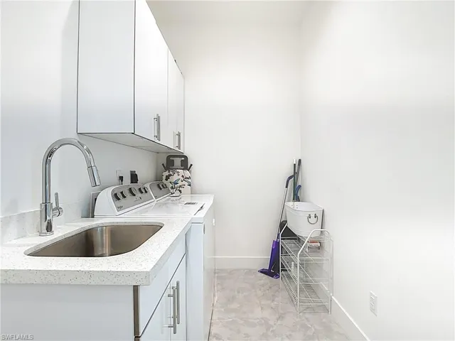 Washroom with cabinet space and washing machine and clothes dryer
