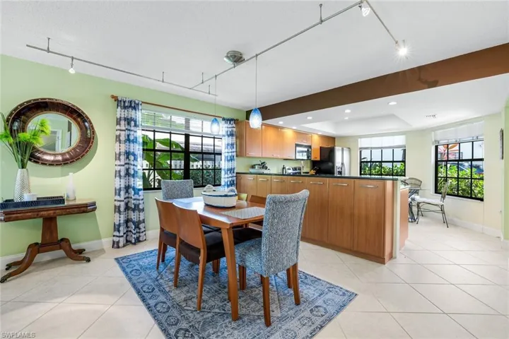 Dining space with rail lighting, plenty of natural light, light tile patterned floors, and recessed lighting