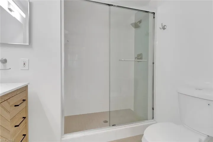 Bathroom with walk in shower, vanity, and toilet