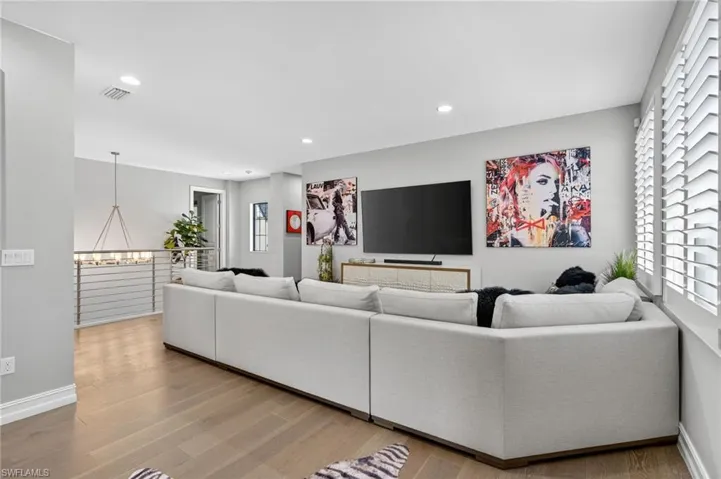 Living area with light wood-style flooring, recessed lighting, and a chandelier
