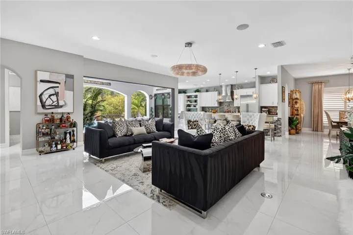 Living area with light marble finish flooring and recessed lighting
