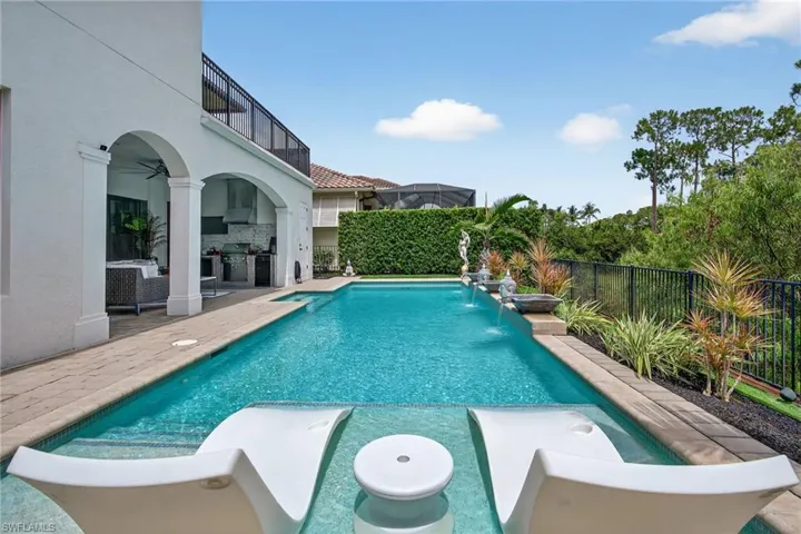 View of swimming pool featuring a patio, a ceiling fan, a fenced backyard, and a balcony