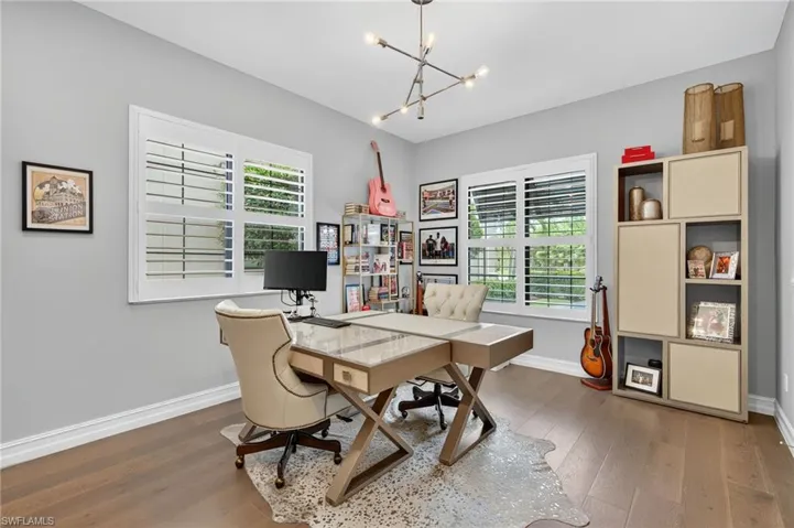 Home office with wood finished floors and a chandelier