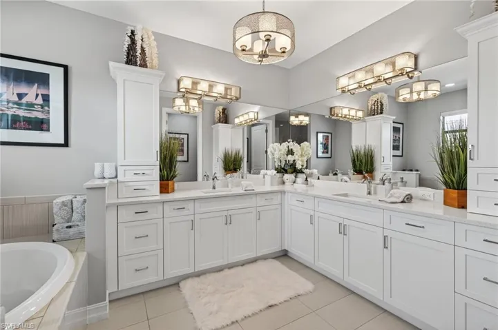 Full bathroom with double vanity, a bath, and light tile patterned flooring