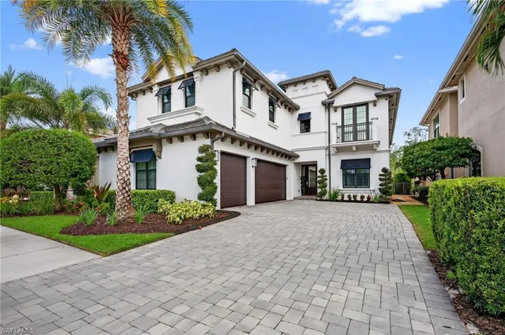 View of front of home featuring stucco siding, a balcony, decorative driveway, and an attached garage