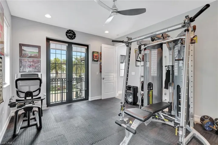 Exercise area with ceiling fan and french doors
