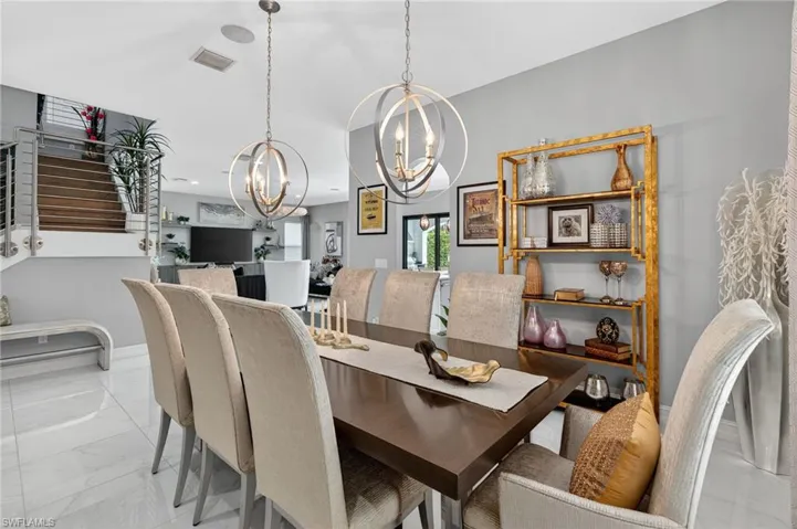 Dining space featuring light marble finish flooring and a chandelier