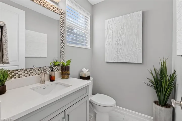 Bathroom featuring vanity and backsplash