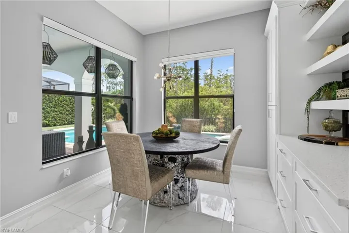 Dining area with light marble finish flooring and a chandelier