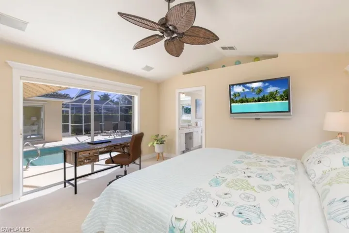 Bedroom with access to exterior, ceiling fan, ensuite bathroom, vaulted ceiling, and carpet