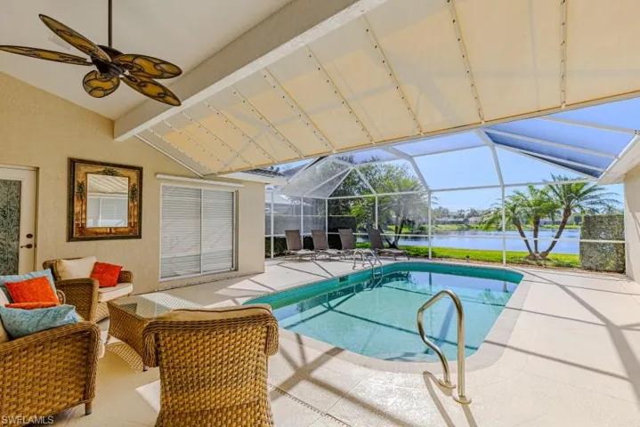 View of pool with a lanai, a patio area, and a water view