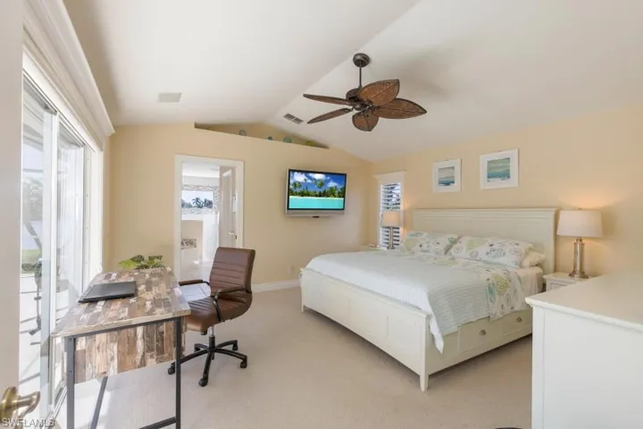 Carpeted bedroom featuring access to exterior, ceiling fan, and lofted ceiling