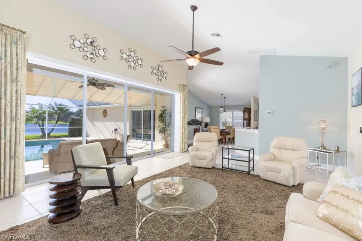 Living room featuring a wealth of natural light, light tile patterned floors, and high vaulted ceiling
