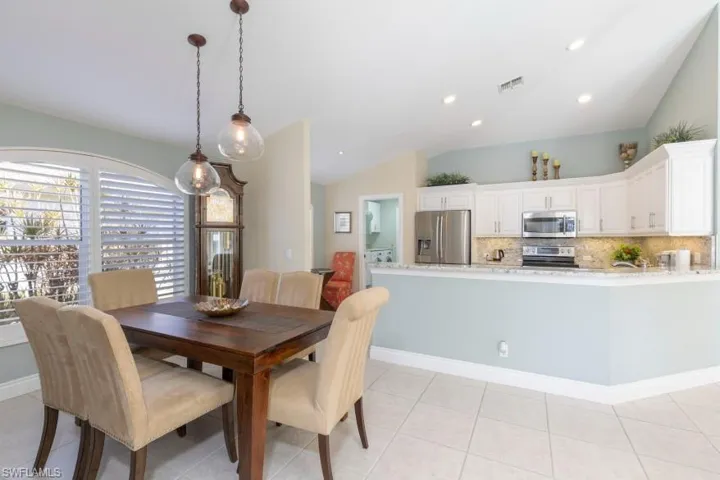 Tiled dining room with lofted ceiling