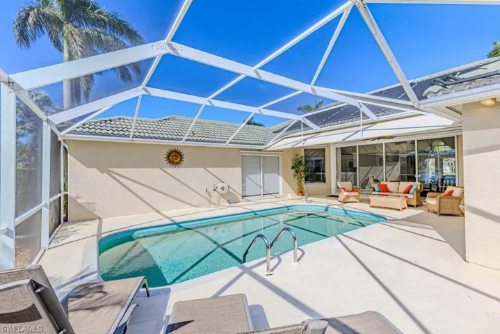 View of swimming pool with an outdoor living space, a patio area, and glass enclosure