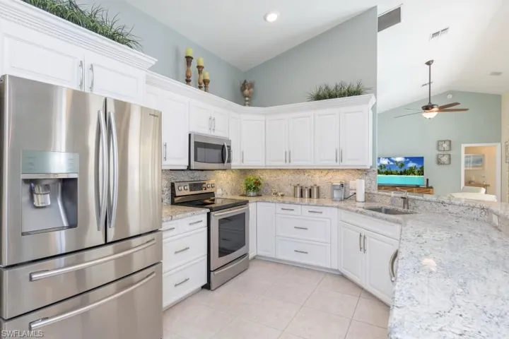 Kitchen featuring white cabinets, sink, and appliances with stainless steel finishes