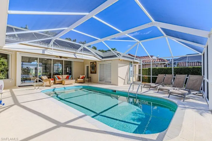 View of pool with an outdoor hangout area, a patio, and a lanai