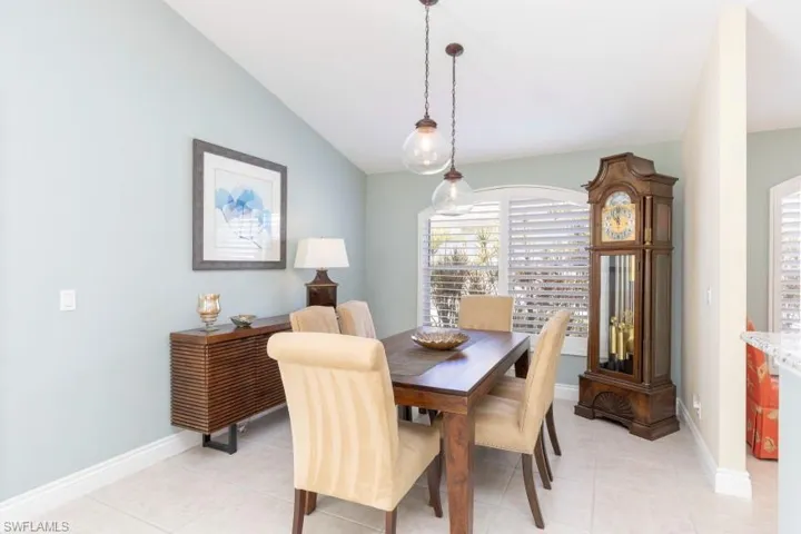 Dining area featuring light tile patterned floors and vaulted ceiling