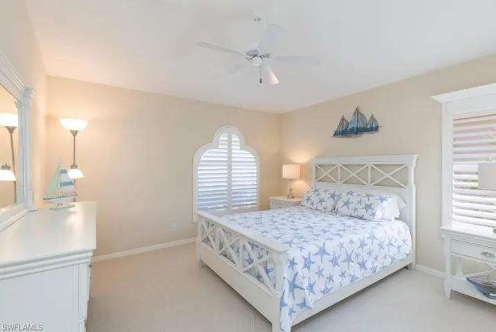 Carpeted bedroom featuring ceiling fan
