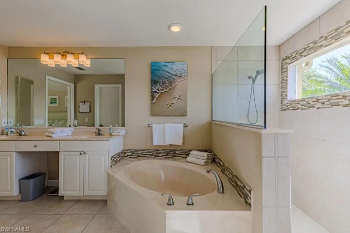 Bathroom with tile patterned floors, vanity, and shower with separate bathtub