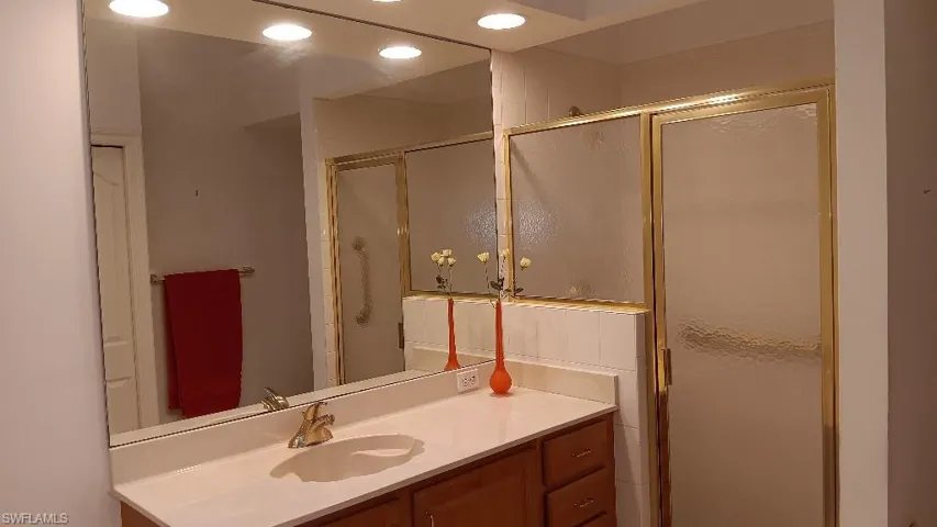 Bathroom featuring an enclosed shower and vanity