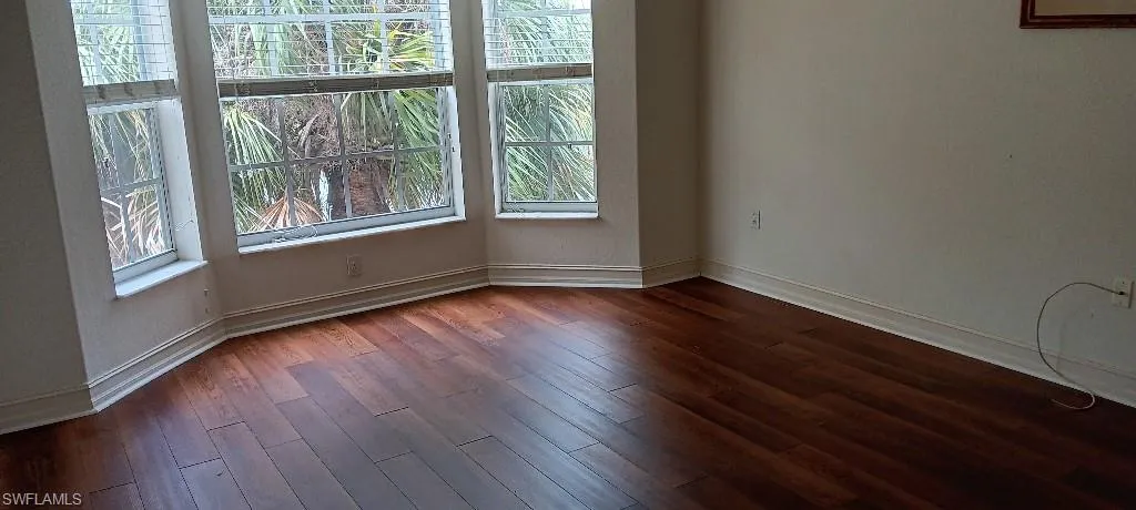 Empty room with dark hardwood / wood-style floors