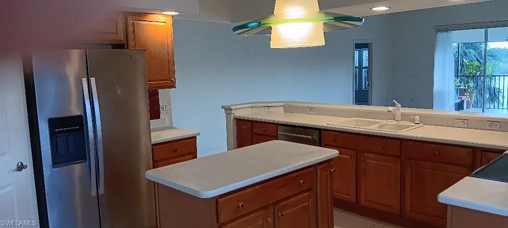 Kitchen with stainless steel refrigerator with ice dispenser, dishwashing machine, light tile patterned floors, sink, and kitchen peninsula