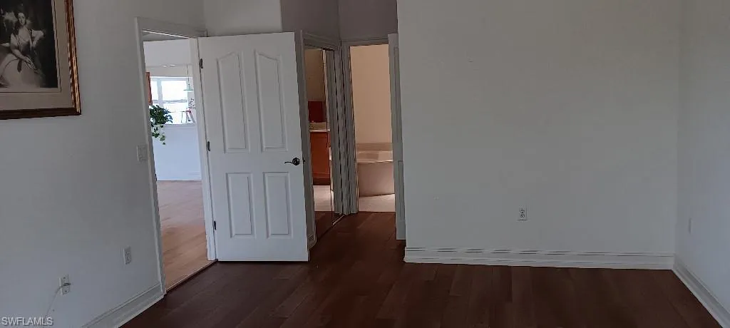 Empty room featuring dark wood-type flooring