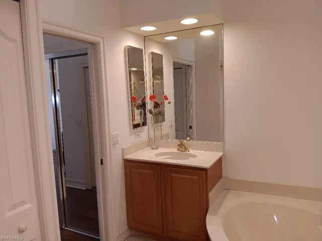 Bathroom featuring a washtub and vanity