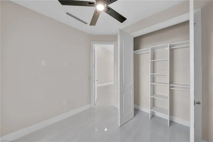 Unfurnished bedroom with ceiling fan, a closet, and light tile patterned floors