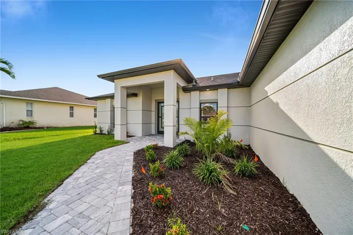 Doorway to property featuring a yard and stucco siding