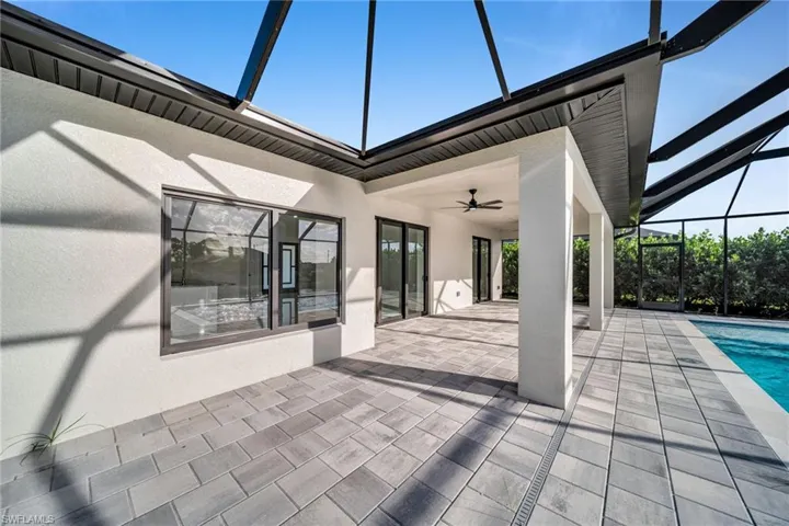 View of patio / terrace featuring a ceiling fan, glass enclosure, a sunroom, and an outdoor pool